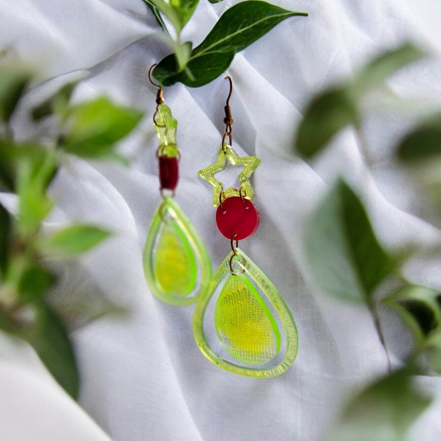 Boucles d'oreille goutes avec étoile mandala en résine vert transparent.