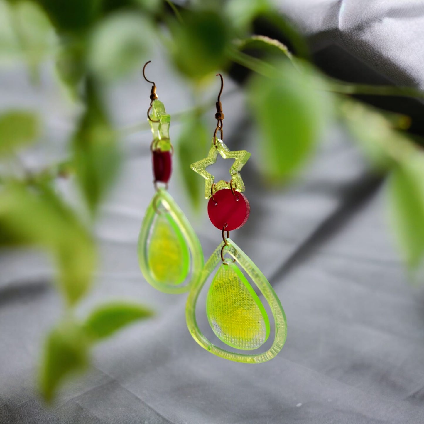 Boucles d'oreille goutes avec étoile mandala en résine vert transparent.